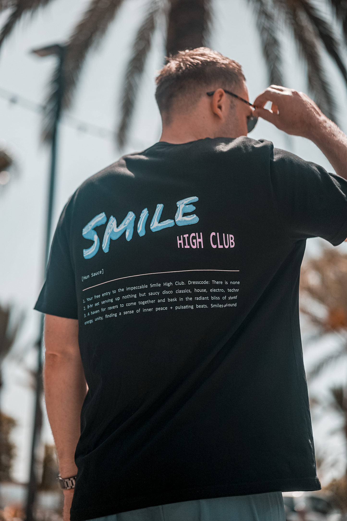 Dj Dan Sterry in Ibiza wearing Hun Sauce, Smile High Club Definition T-Shirt in black. Defining the Smile high club