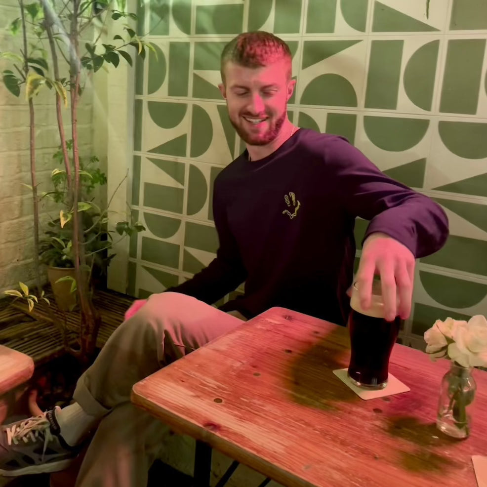 Model wears SMILE HIGH CLUB Black Long Sleeve T-Shirt - Hun Sauce  - smiley disco rave poster, for house music, techno and disco. One for the dancefloor and Rave Wardrobe